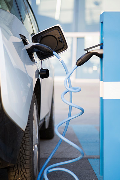 An,Electric,Car,Is,Being,Charged,At,A,Charging,Station EV Manufacturer, EV Vehicle at Charging Station